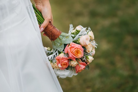 Bride holding wedding bouquet of various flowers