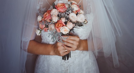 Bride holding wedding bouquet of various flowersの写真素材