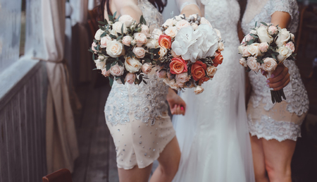 Happy bride and bridesmaids holding bouquets, posingの写真素材
