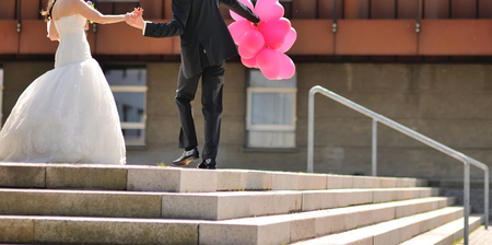 Happy young bride and groom together, wedding couple with pink ballons walking in Copenhagenの写真素材
