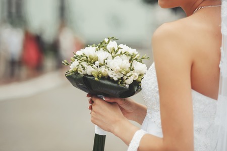 Bride holding bridal bouquet at street.の写真素材