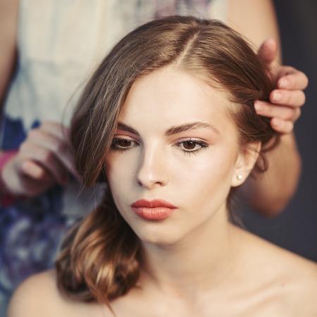 Professional hairdresser with young model.