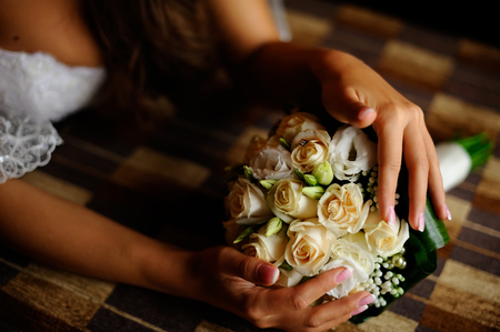 Bride holding wedding bouquet made of white rosesの写真素材