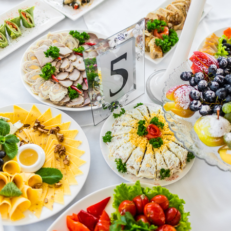 Plate with different cheese at banquet table in restaurant served with different meals. Ready for wedding reception.の写真素材