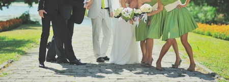wedding couple with friends, bride with bouquet of white rosesの写真素材
