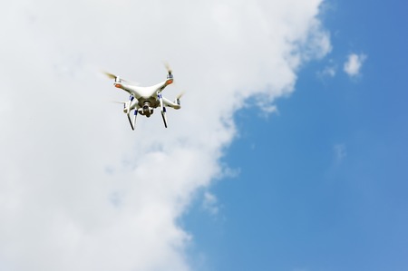 drone quad copter with high resolution digital camera flying hovering in the blue skyの写真素材