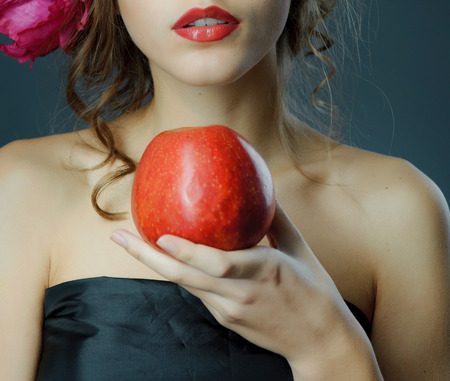 Red lips with red apple. Young woman spring studio shot.の写真素材