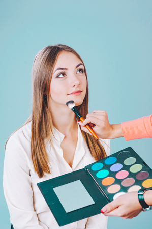 Young girl having make up applying by artist in studioの写真素材