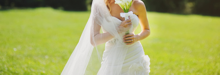 beautiful bride in stylish wedding dress holding a bouquet
