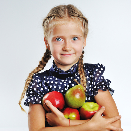 young school girl playing with fruits in a classroomの写真素材
