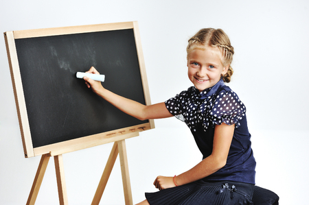 young school girl drawing in a classroomの写真素材