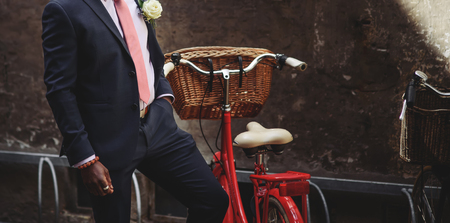 Stylish groom and red bicycle with the basketの写真素材