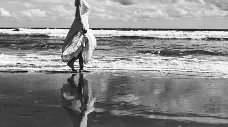 Bride walking by the sea wearing stylish classic wedding dress.