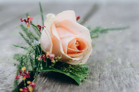 Stylish wedding boutonniere on a wooden floor.