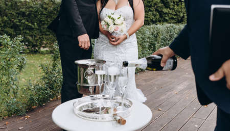 Wedding registrar fill glasses with champagne for happy bridal couple.の写真素材