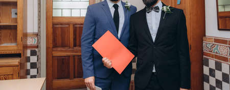 Newlyweds gay couple with their official marriage certificate.の写真素材