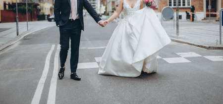 Wedding couple walking the street together celebrating happy wedding day. Wedding agency concept.の写真素材