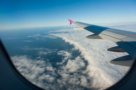 Wing of a jet on the blue sky background. Concept of travel and air transportation industry.の写真素材
