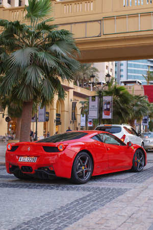 Dubai, UAE - November 20, 2013. Red Ferrari driving in Dubai Maria district.