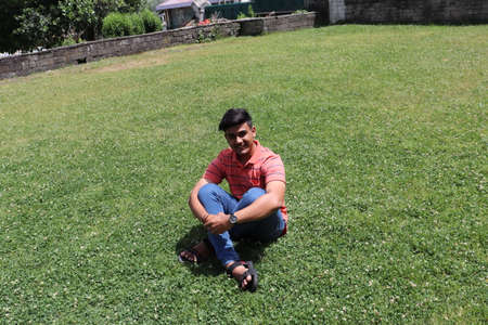 Himachal Pradesh, India - July 16, 2019: A boy sunbathing on a lawnのeditorial素材