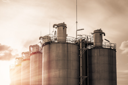 Silos in petrochemical industry, Old silo storage for plastic resins with sky sunrise