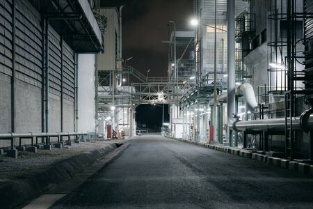 Factory building and road of industrial plant at nightの写真素材