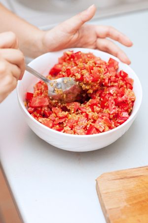 Mixing bulghur and tomatoes for tabouleh saladの写真素材