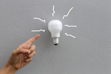 bulb and hand on gray backgroundの写真素材