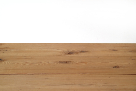 brown wooden floor with white wall in background
