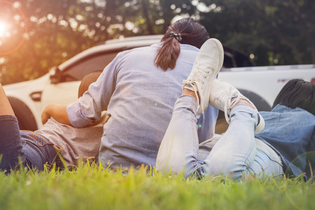 a girl and a woman  sitting for  relax on the grass with happinessの写真素材