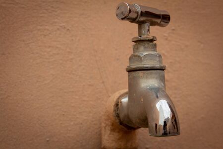 Close view of stainless steel water tap in building exterior