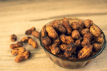 Steamed peanuts in a glass bowl. Groundnuts unpeeled in a bowl.
