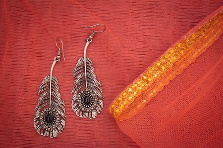 View of beautiful earrings against textured cloth.