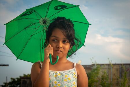 Cute little girl with umbrella on a sunny day