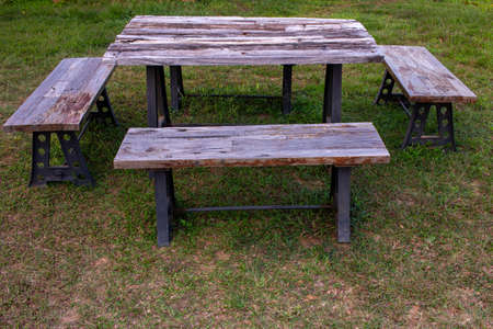 A wooden picnic bench used for eating outdoor. Park bench for recreation.