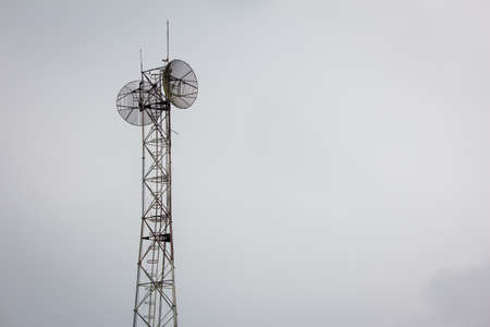 Communication tower with the overcast sky background.の写真素材
