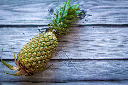 View of a pineapple against a wooden background. Use for fruit concept.