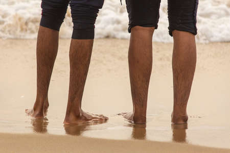 Friends enjoying the waves in the beach, Marina Beach, Chennai. Focus set on footの写真素材