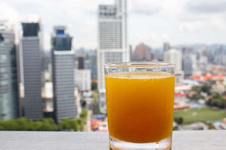 Chilled freshly squeezed orange juice in a glass with high rise backgroundの写真素材