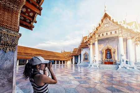 Tourist girl taking pictures of Marble temple in Bangkokの写真素材