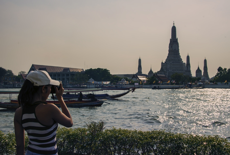 Tourist girl taking pictures of Arun Wat in Bangkokの写真素材