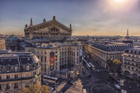 Paris roofs viewed from Haussmann boulevard with the famous Palais Garnier and the Eiffel Tower
