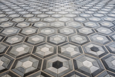 Geometric hexagon pattern tiled floor in monochromatic gray and white hues, creating a mesmerizing and symmetrical visual effect in a modern minimalist setting.の素材
