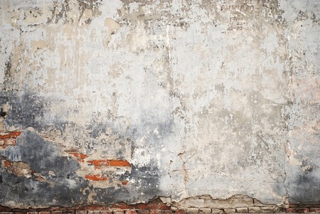 abandoned grunge cracked brick stucco wall backgroundの写真素材