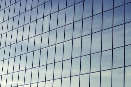 dirty glass windows of an office building, reflection of skyの写真素材