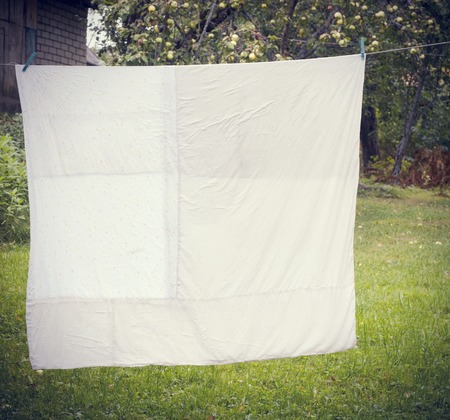 white washed duvet hanging in the yardの写真素材