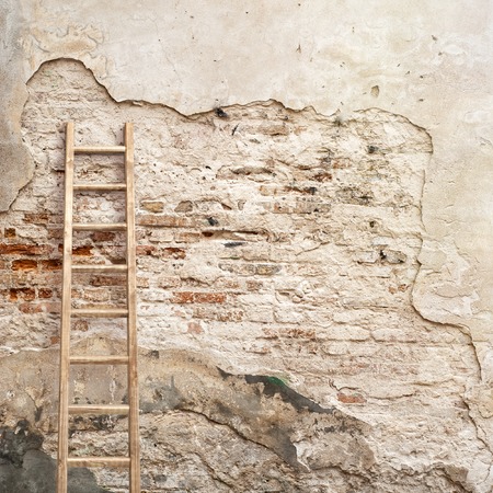 weathered stucco wall with wooden ladder backgroundの写真素材