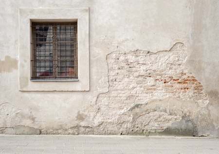 abandoned grunge cracked brick stucco wall with a window grillesの写真素材