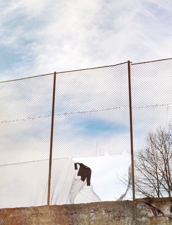 Sweater hanging on the metal mesh fence in football stadium