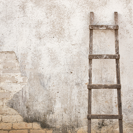 weathered stucco wall with wooden ladder backgroundの写真素材